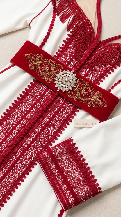 Close-up detail of ornate red embroidery, fringe neckline, and velvet belt with rhinestone brooch