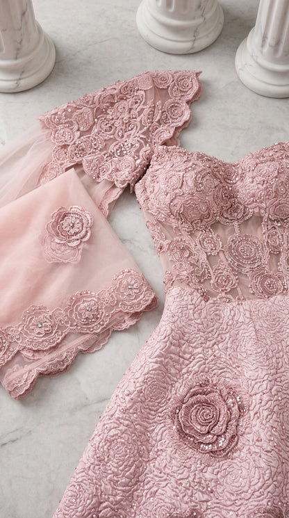 Close-up detail of textured floral jacquard fabric and lace trimmed cape overlay