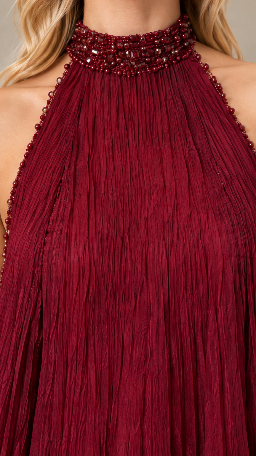 Close-up of beaded halter collar and micro-pleated burgundy fabric