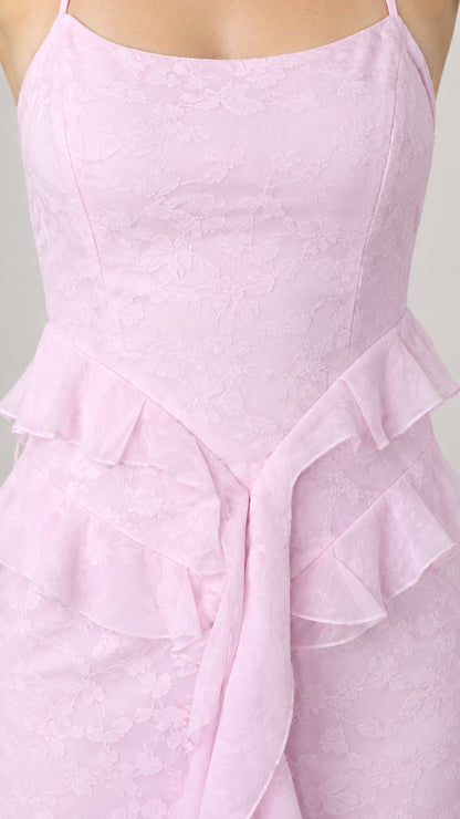 Close-up detail of pastel pink floral jacquard texture and layered waist ruffles