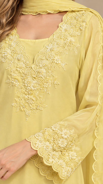 Close-up detail of yellow floral lace neckline embroidery and scalloped sleeve cuffs