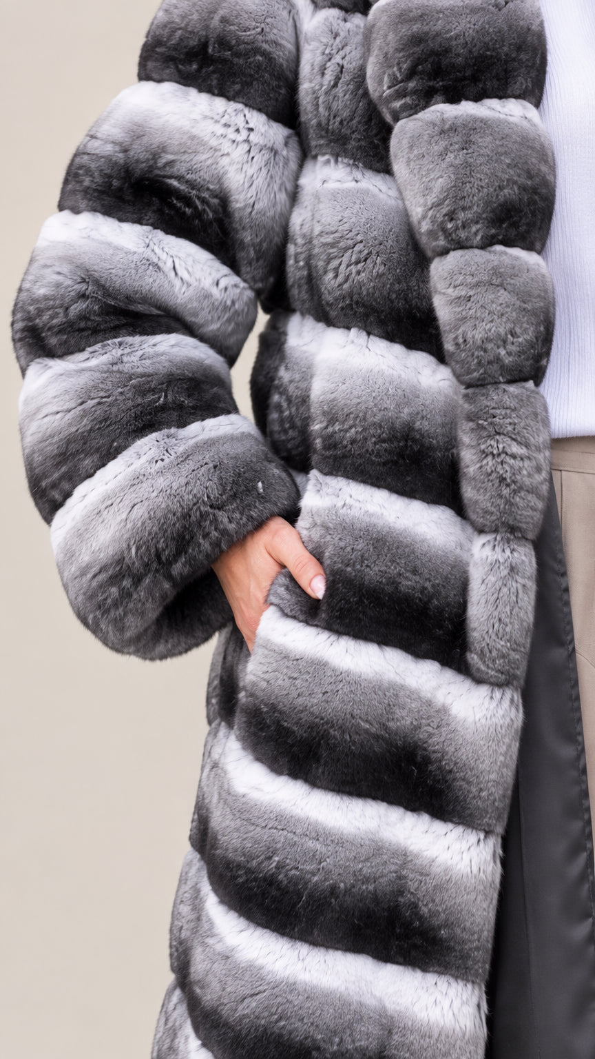 Close-up detail of plush horizontal stripes, sleeve texture, and side pocket on faux fur coat