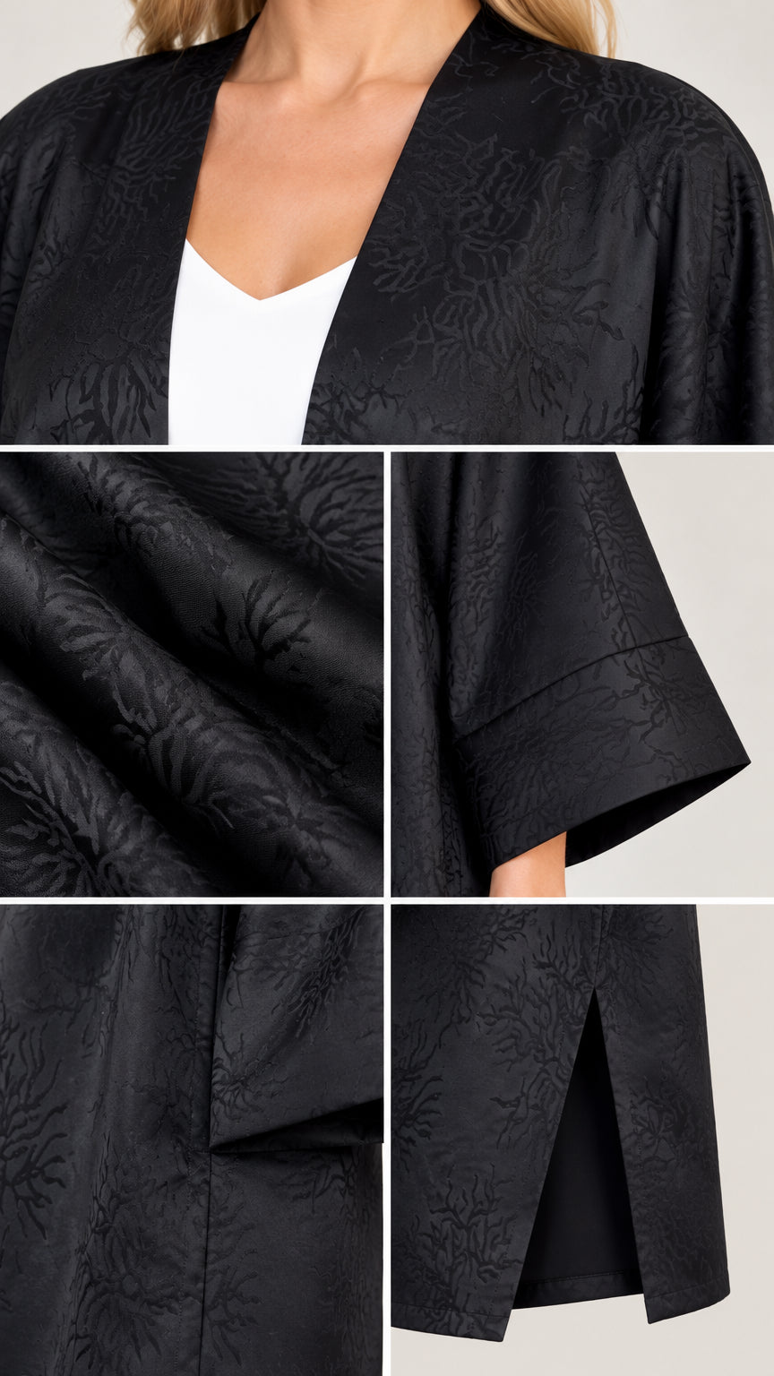 Close-up details of black jacquard fabric texture, sleeve cuff, and side slit