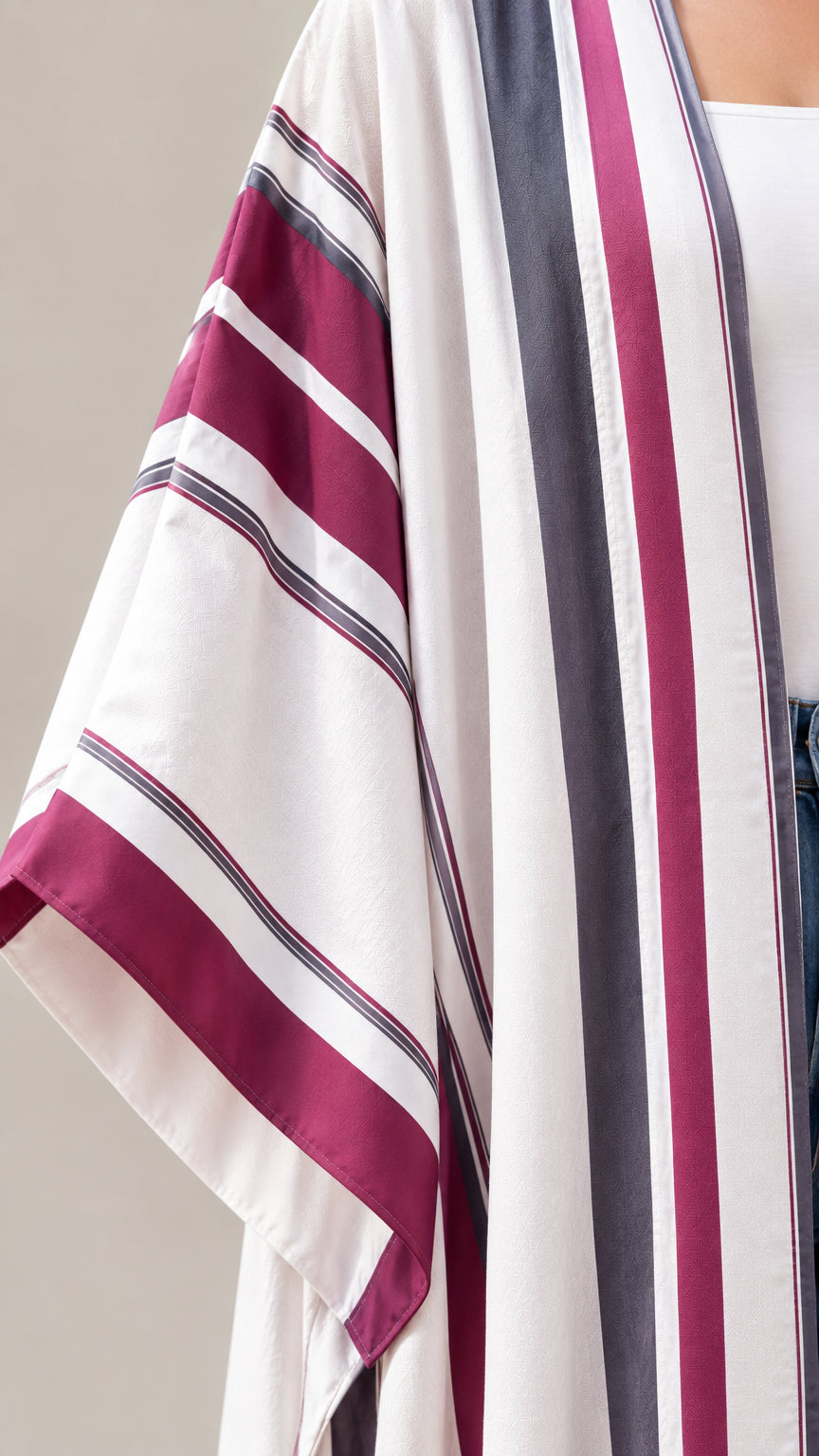 Close-up detail of burgundy and grey stripe cuff and hem pattern on off-white kimono fabric