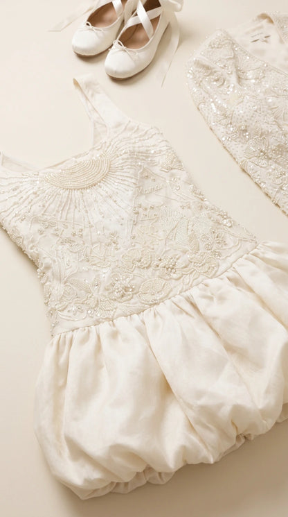 Flat lay close-up of intricate beading and embroidery on ivory mini dress bodice