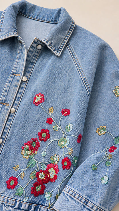 Close-up detail shot of colorful red and green floral embroidery on denim fabric and collar