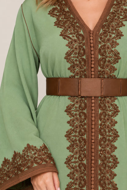 Close-up of brown lace embroidery and belted waist on green dress