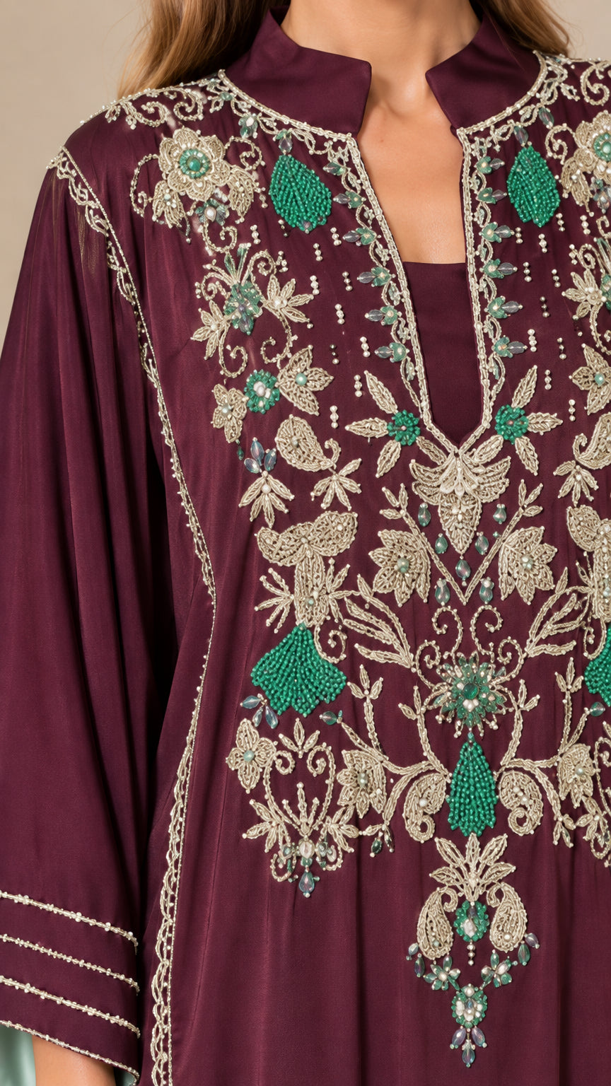 Close-up of intricate floral embroidery and beading on the split neckline of burgundy dress