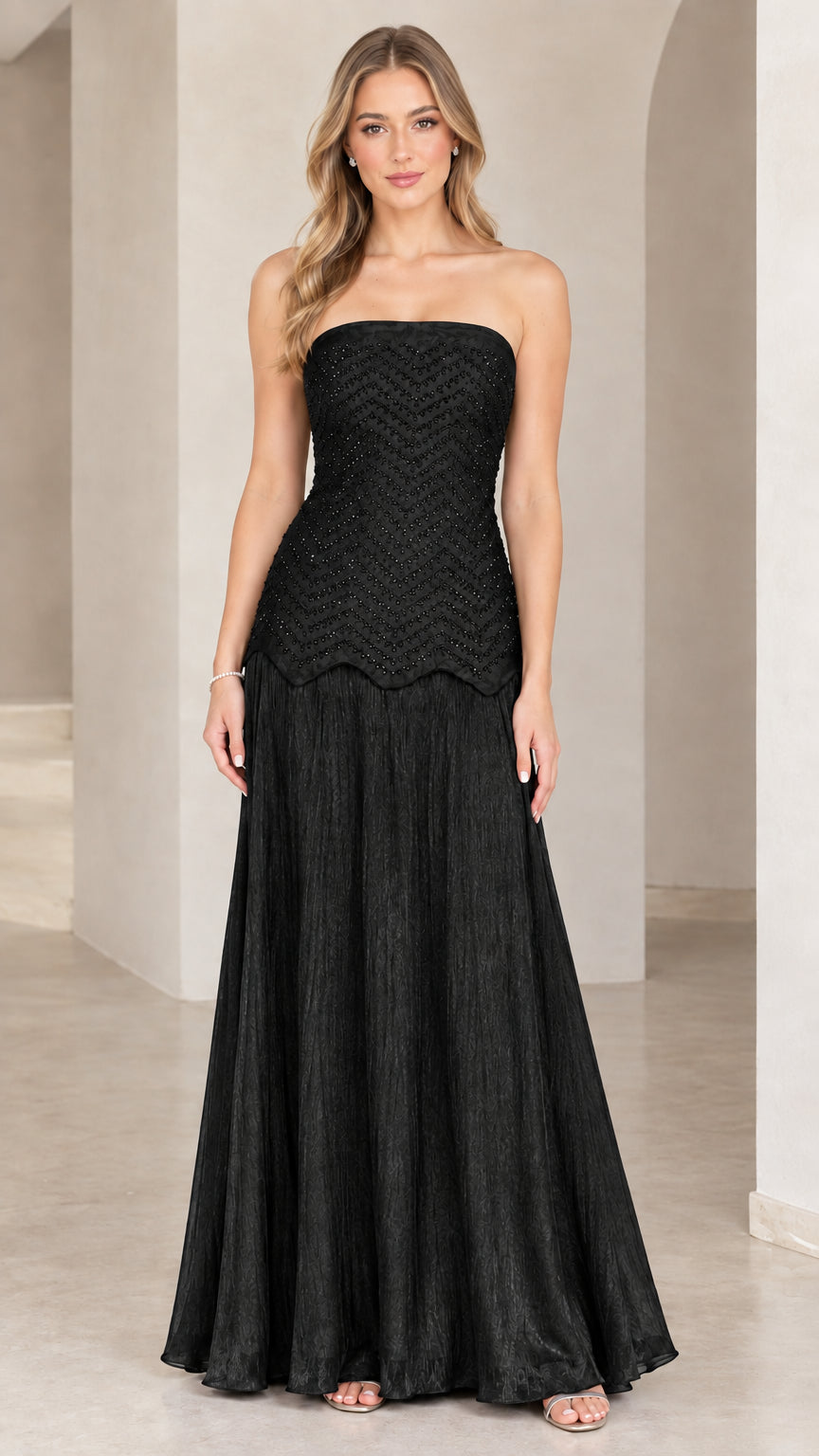 Full-length view of model in black strapless beaded evening maxi gown