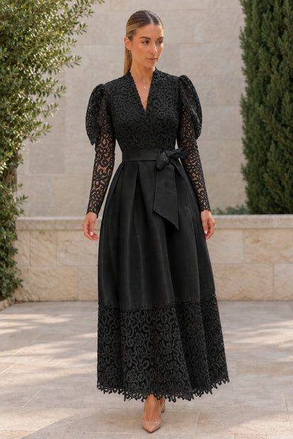 Woman wearing black floral lace puff long sleeve belted satin maxi dress