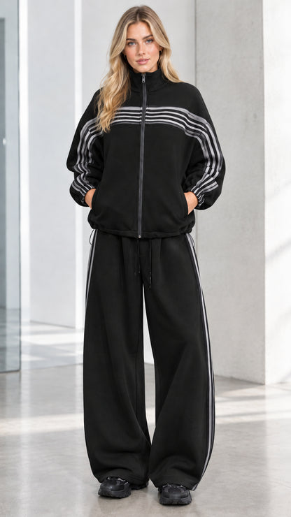 Front full view of woman wearing Black striped zip-up track jacket and wide-leg sweatpants set