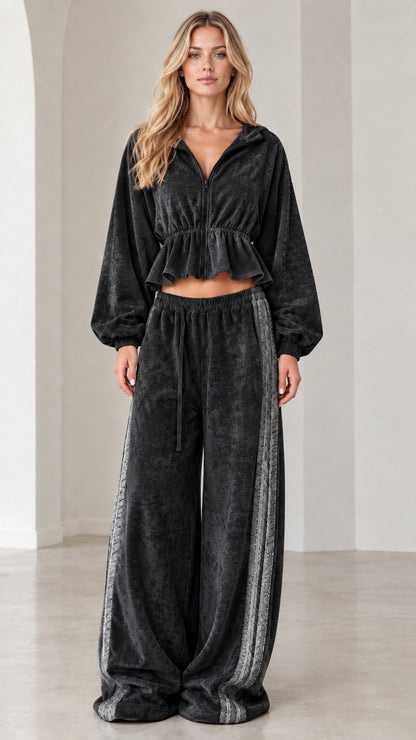 Full-length view of model wearing black velour cropped tracksuit set with side stripe wide-leg pants