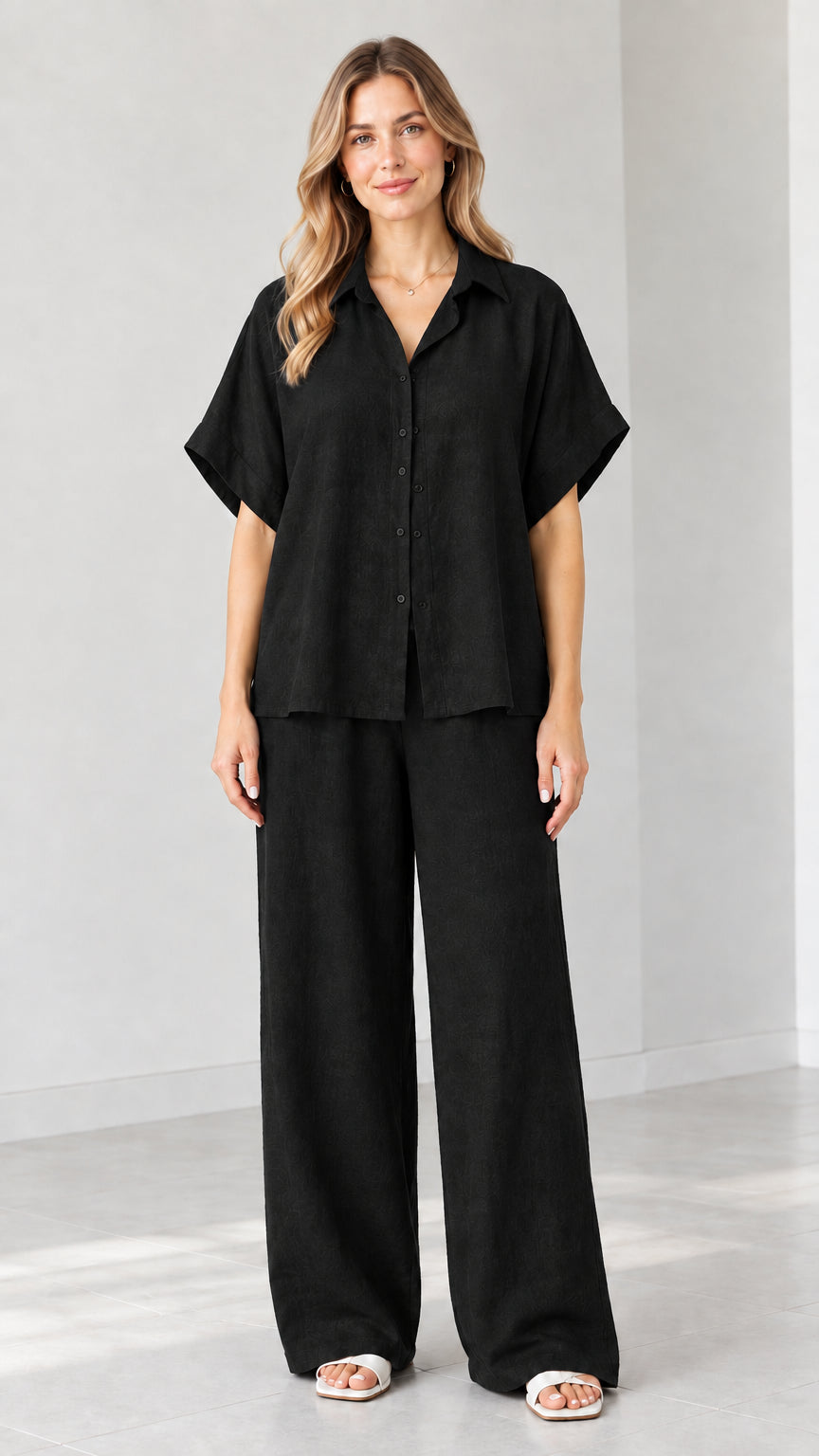 Model wearing Black short-sleeve collared shirt and wide-leg pants set
