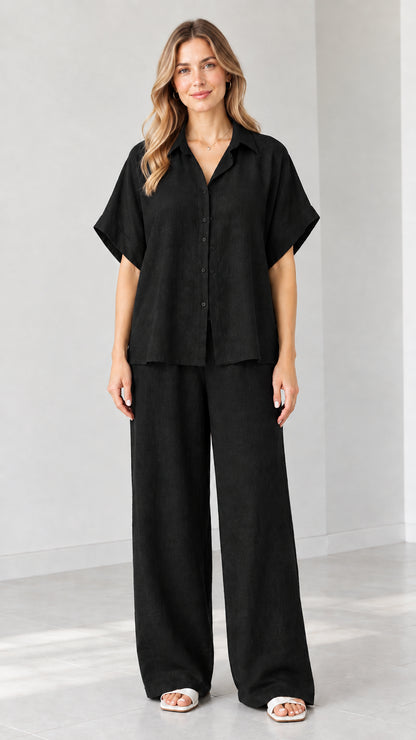 Model wearing Black short-sleeve collared shirt and wide-leg pants set