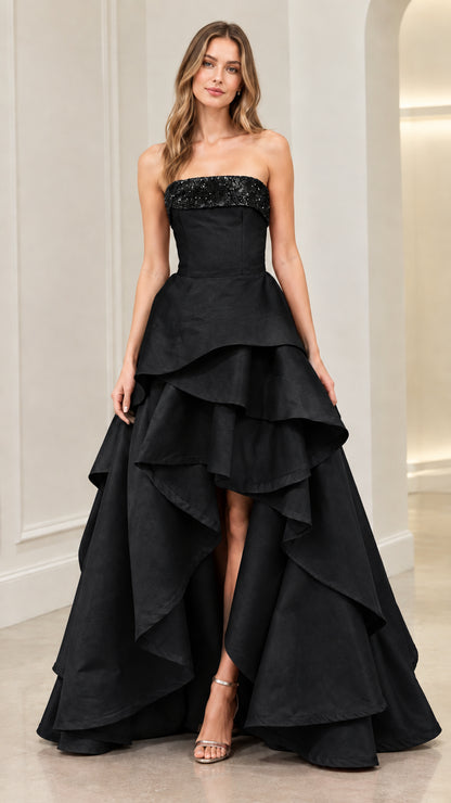 Front view of model wearing Black strapless tiered high-low formal evening dress