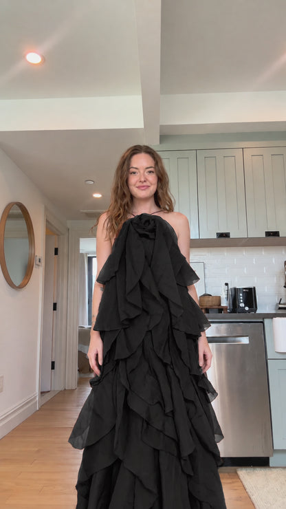 Front view of model wearing classic black tiered ruffle rosette maxi dress