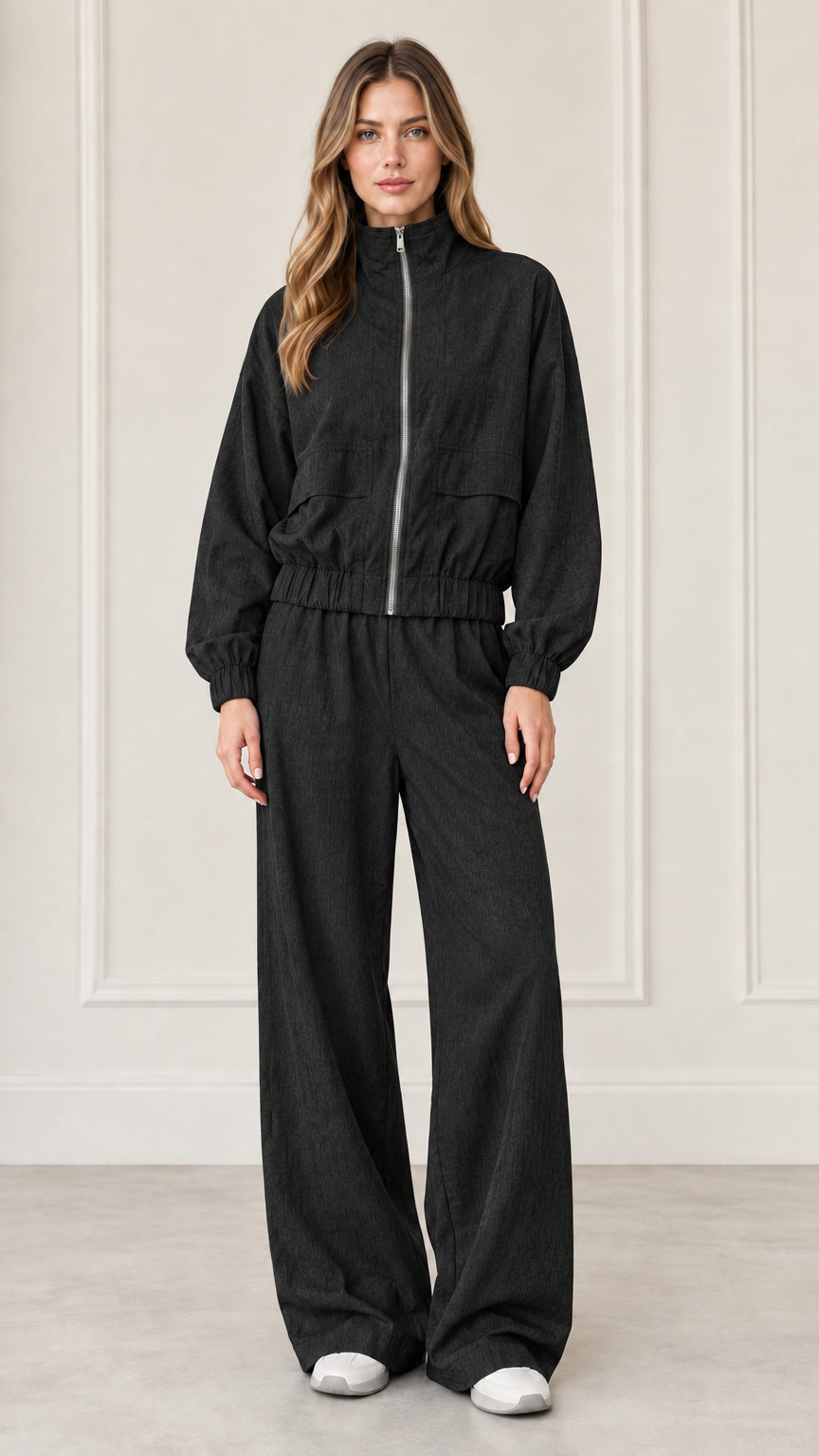 Front full-length view of woman wearing Black zip-up jacket and wide-leg pants set