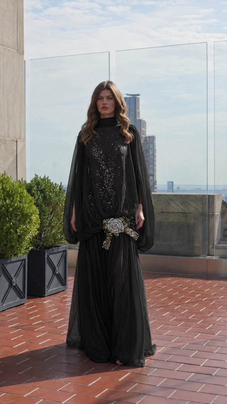 Model wearing black high-neck cape sleeve maxi evening gown