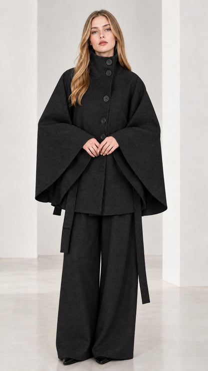 Front view of black high neck belted cape coat and wide-leg trousers set