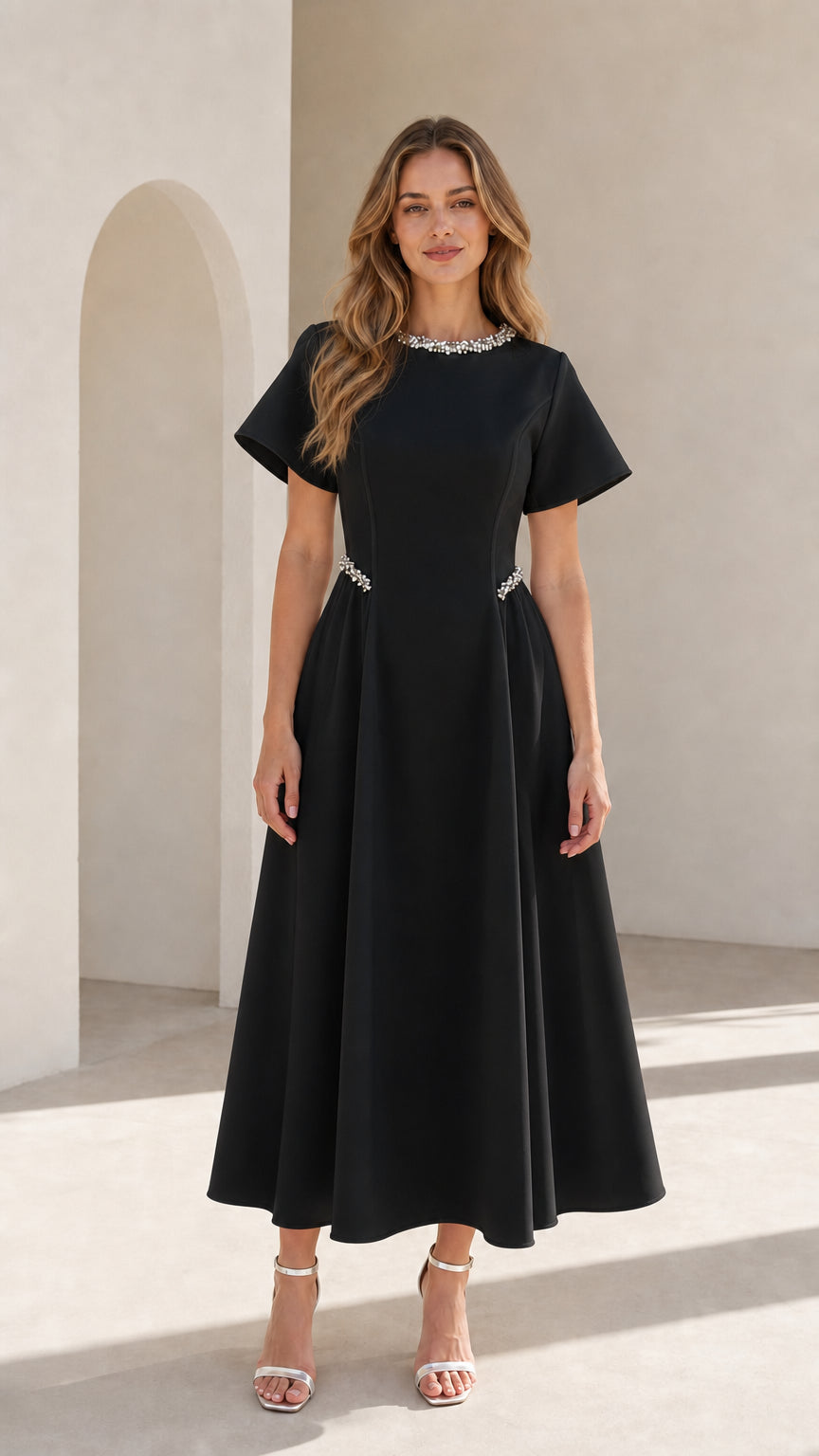 Front view of woman wearing black pearl embellished A-line midi dress