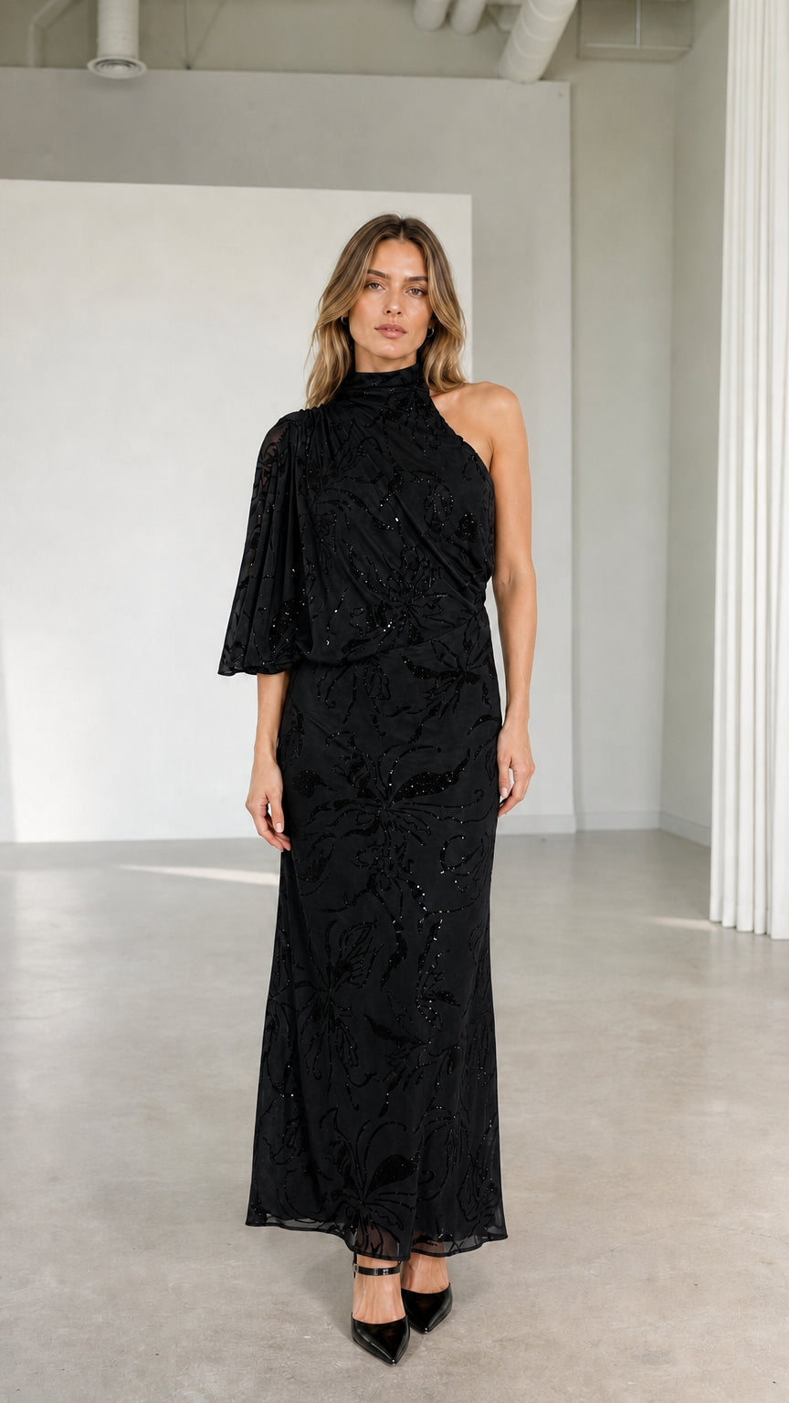 Model wearing black one-shoulder high neck embellished maxi evening gown