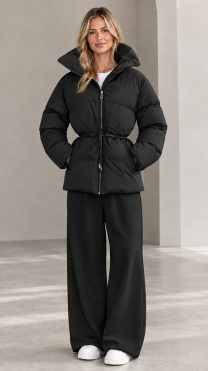 Front view of woman wearing black hooded cinch-waist puffer jacket