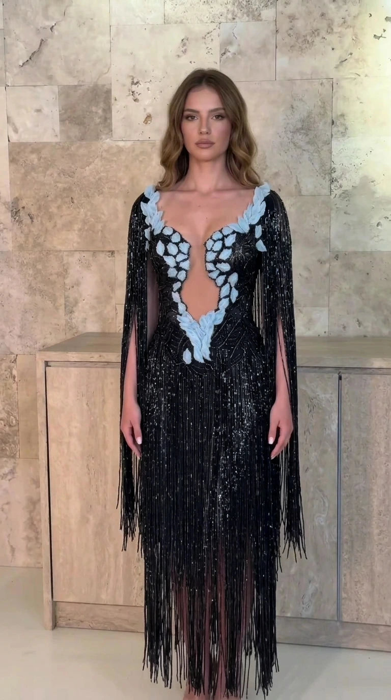 Front view of model wearing black beaded fringe cape sleeve evening gown