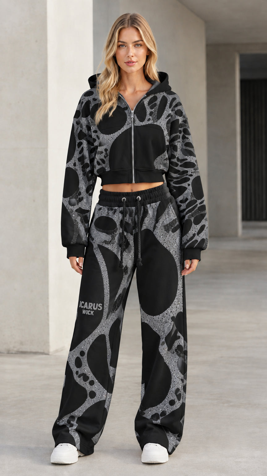 Front view of model wearing black graphic cropped zip hoodie and wide-leg sweatpants