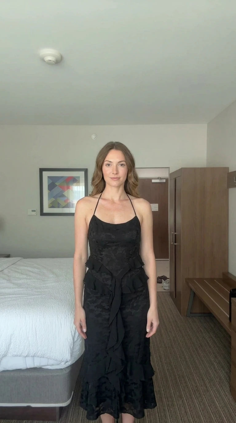 Front view of woman wearing black floral jacquard halter maxi dress