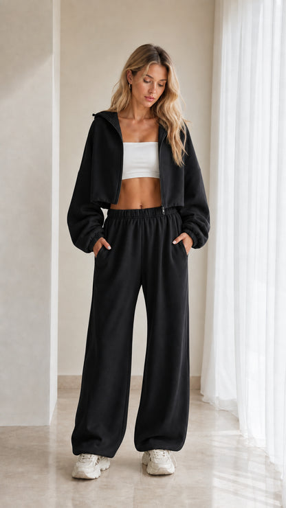 Model wearing black 2-piece cropped hoodie and wide leg sweatpants set