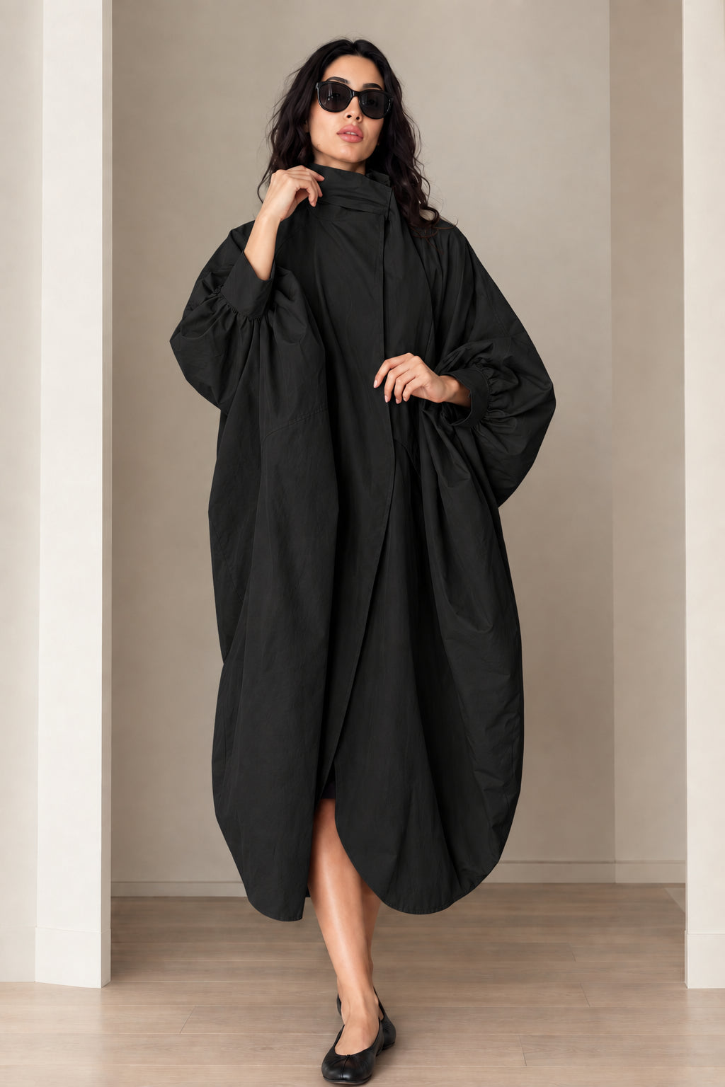 Model wearing black oversized cocoon long coat with high stand collar
