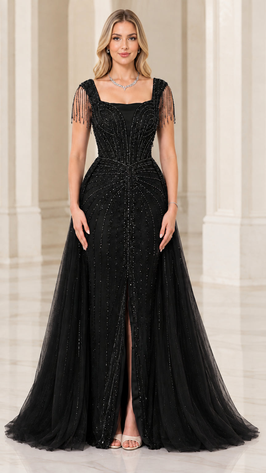 Full-length front view of black beaded formal gown with fringe sleeves and tulle overskirt