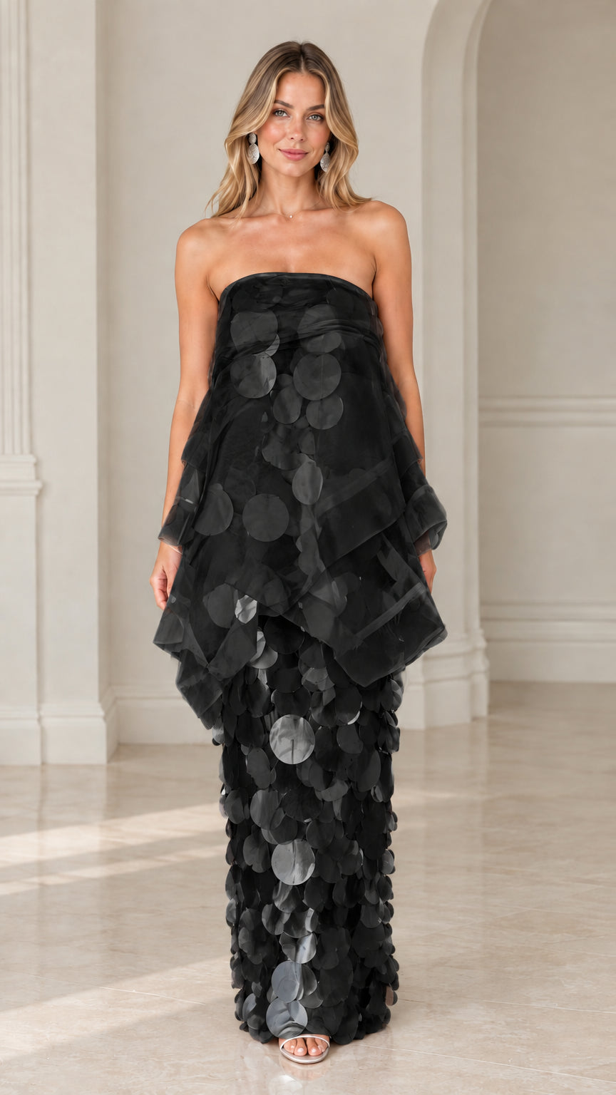 Front view of model wearing black strapless tiered organza paillette maxi dress
