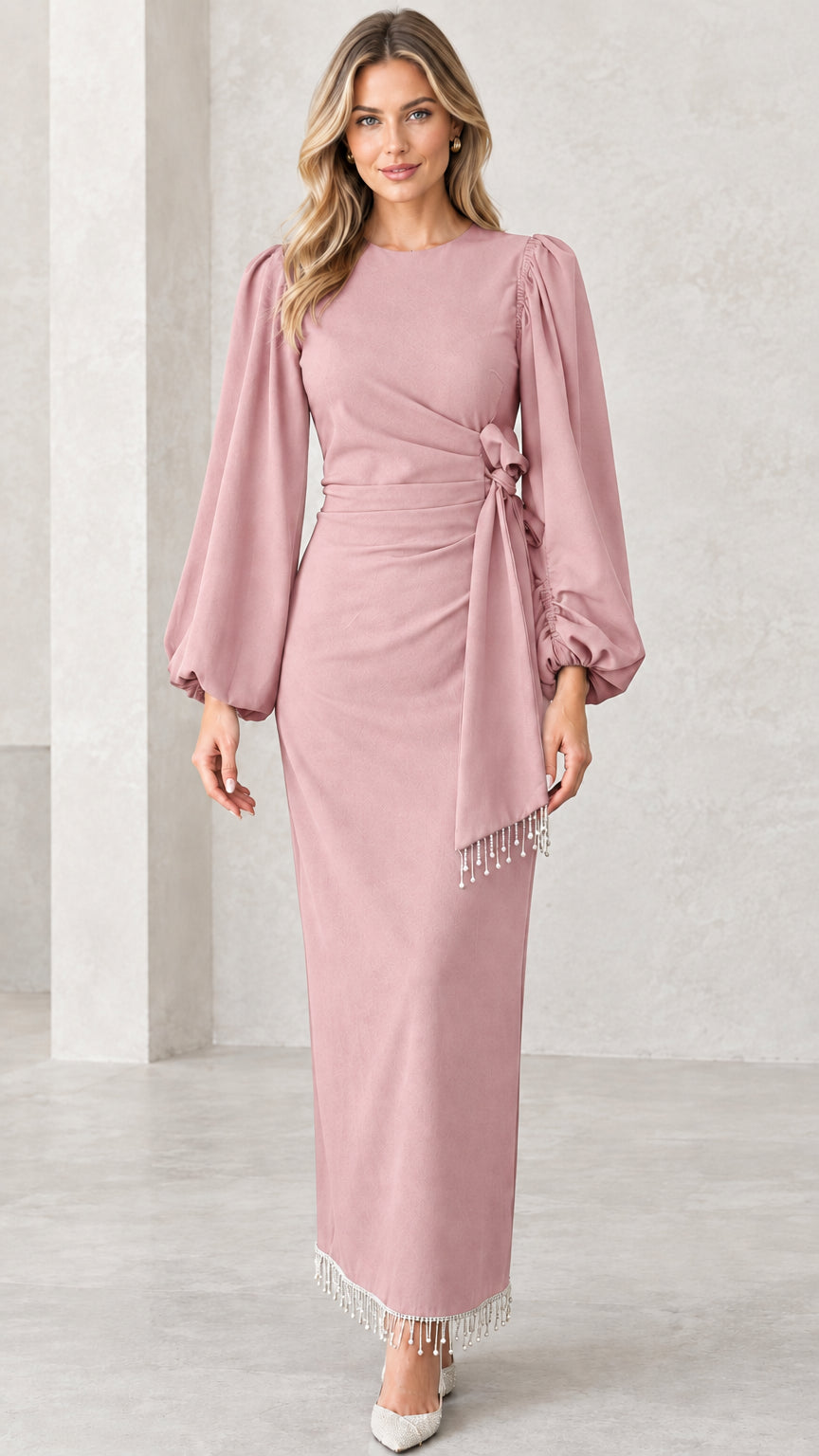 Front view of dusty pink draped long sleeve maxi evening dress with fringe trim