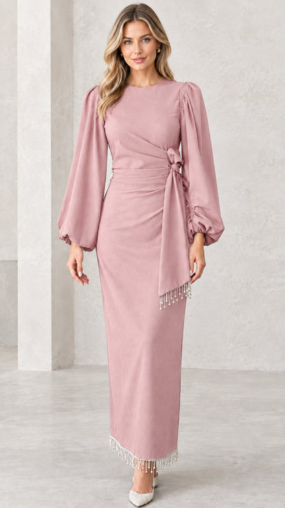 Front view of dusty pink draped long sleeve maxi evening dress with fringe trim
