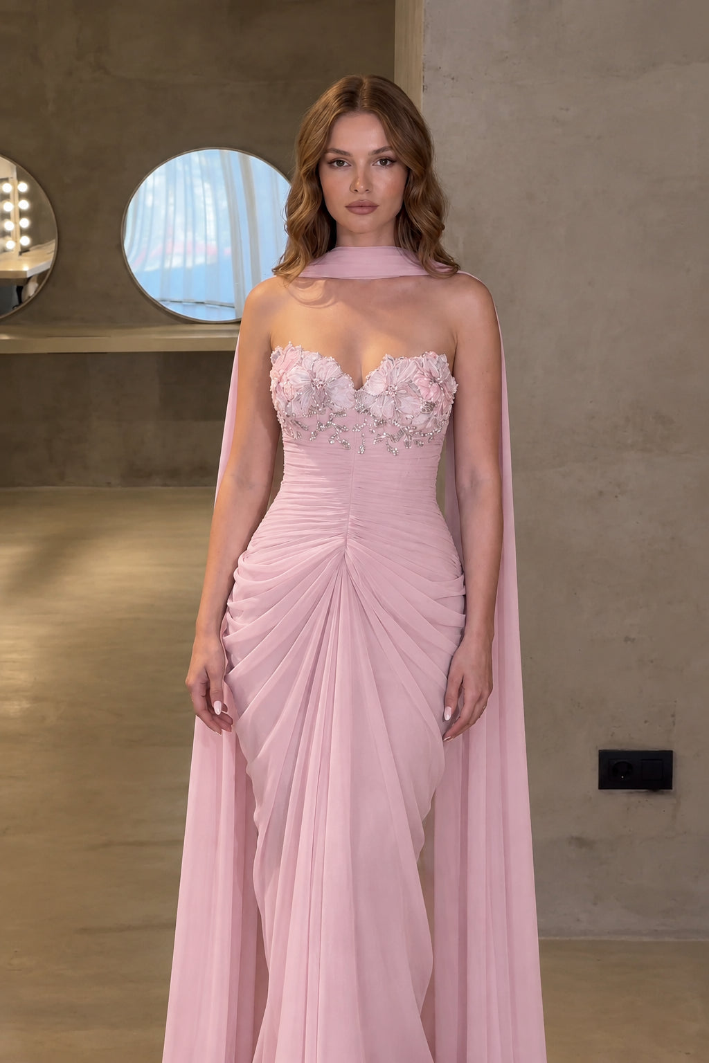 Front view of blush pink floral bodice ruched formal gown with draped scarf