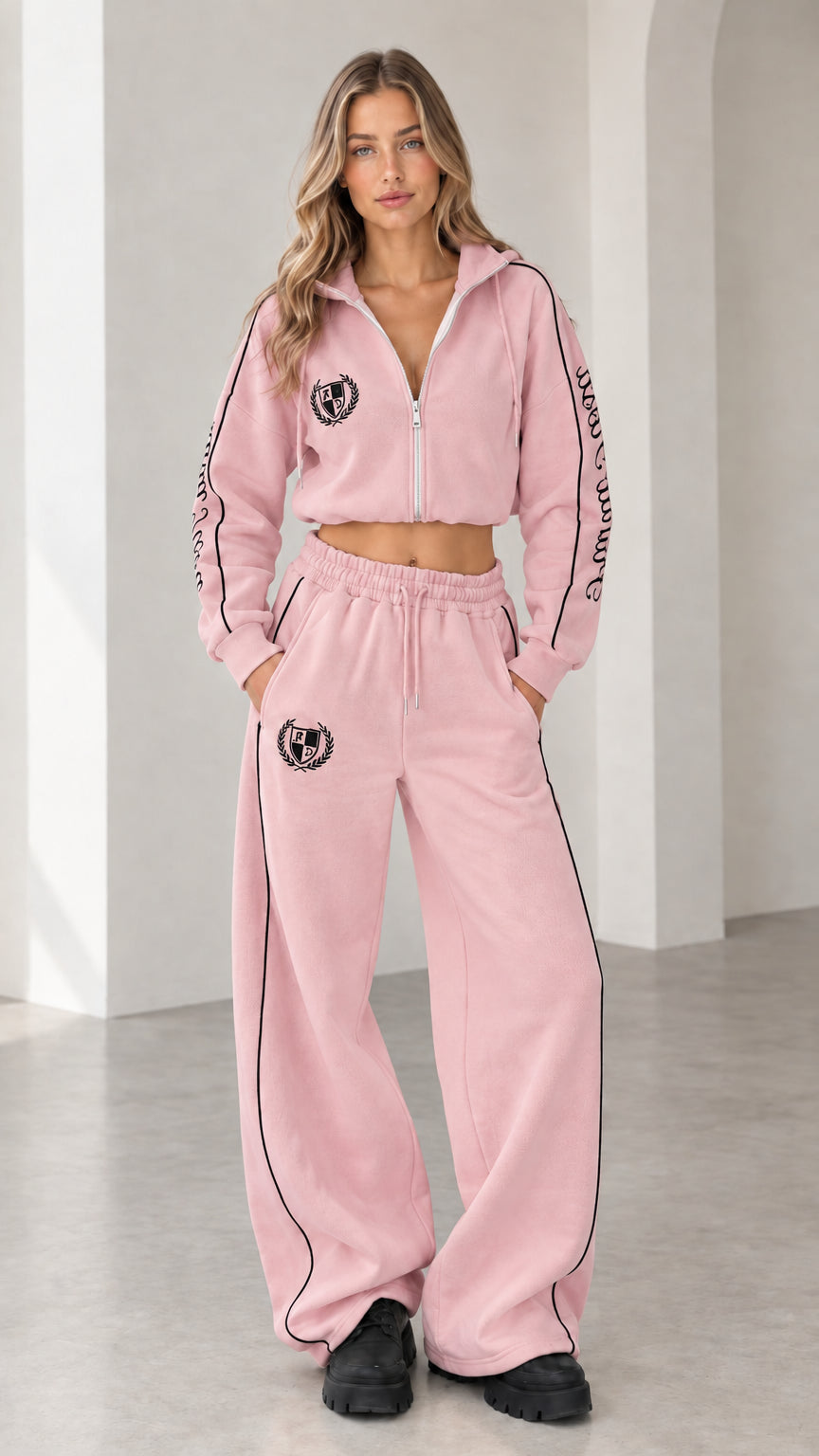 Front view of model wearing pastel pink cropped hoodie and wide-leg sweatpants tracksuit set