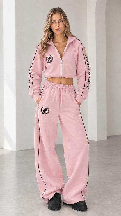Front view of model wearing pastel pink cropped hoodie and wide-leg sweatpants tracksuit set
