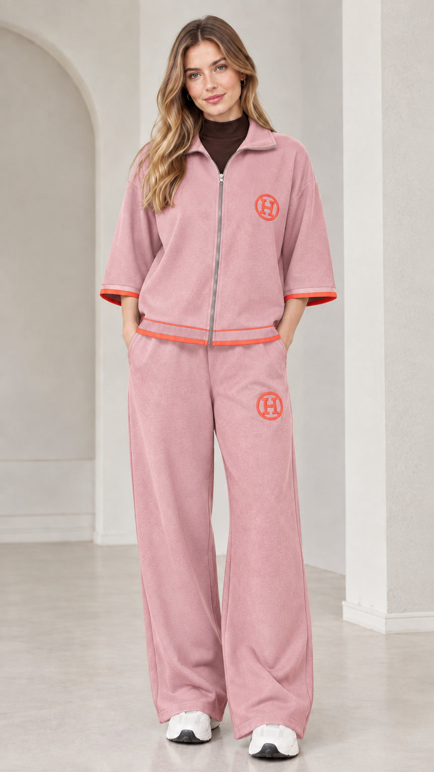 Front view of woman wearing dusty pink two-piece zip-up tracksuit set