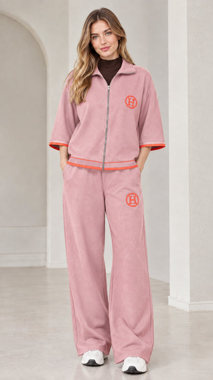 Front view of woman wearing dusty pink two-piece zip-up tracksuit set