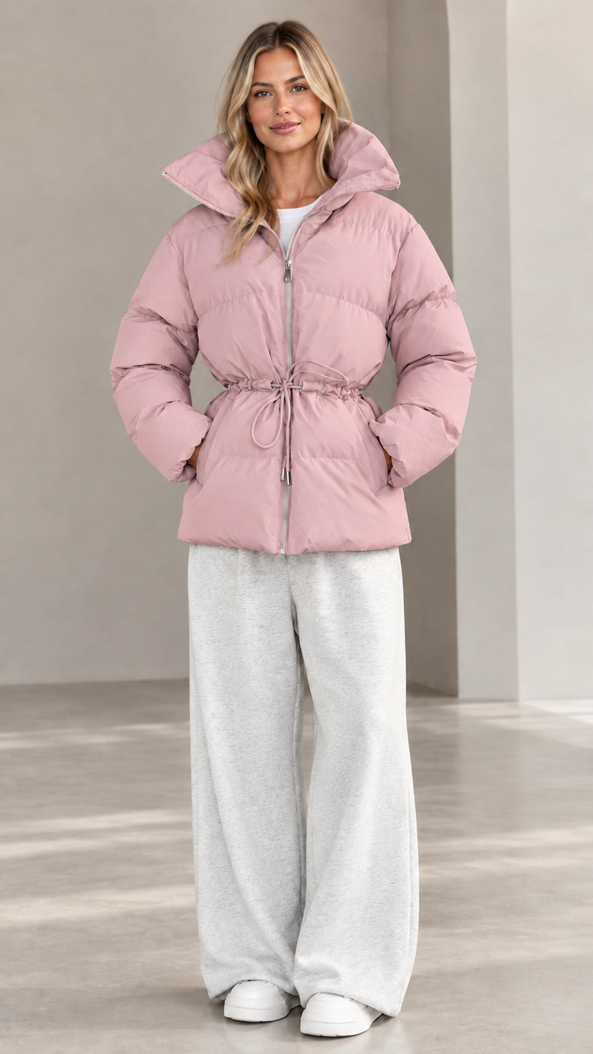 Front view of woman wearing dusty pink hooded cinch-waist puffer jacket