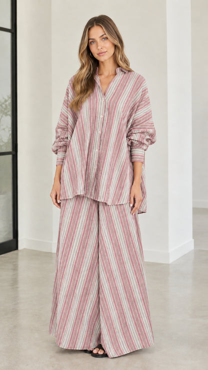 Model wearing rose pink vertical striped matching button-down shirt and pants set