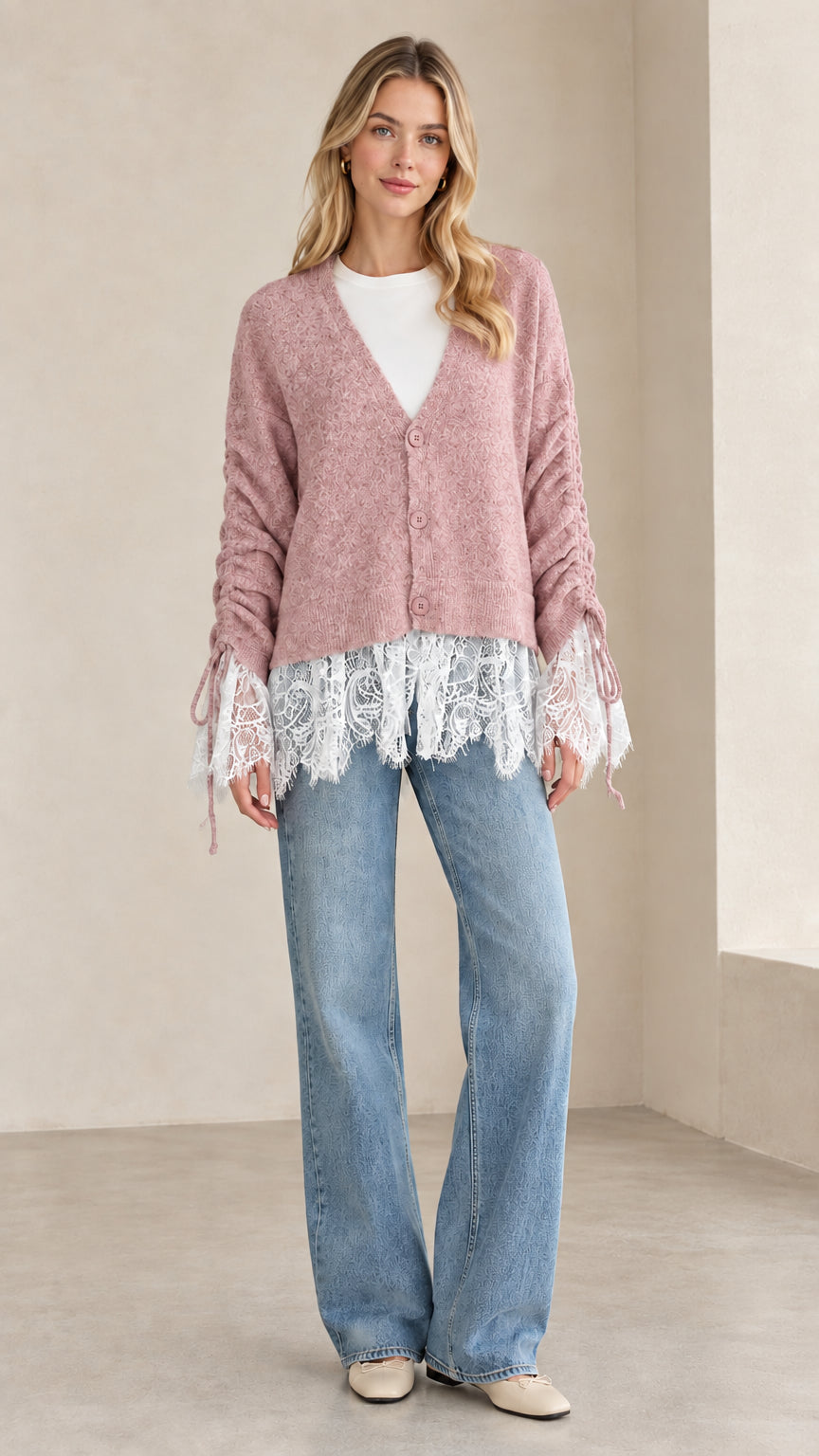 Front view of woman wearing dusty pink V-neck lace-trimmed knit cardigan