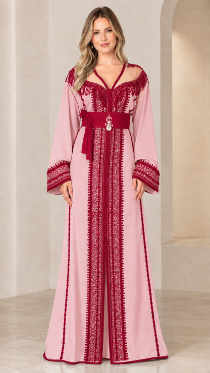 Model wearing dusty pink embroidered caftan maxi dress with maroon trim