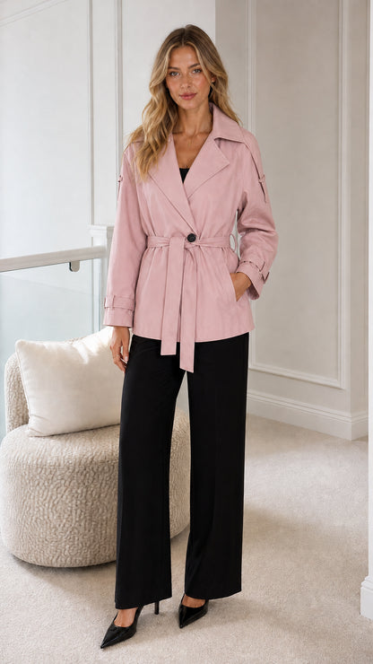 Model wearing blush pink short belted trench coat with lapel collar