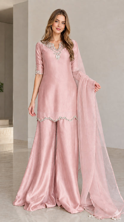 Model wearing dusty pink embellished kurta sharara 3-piece set with matching dupatta