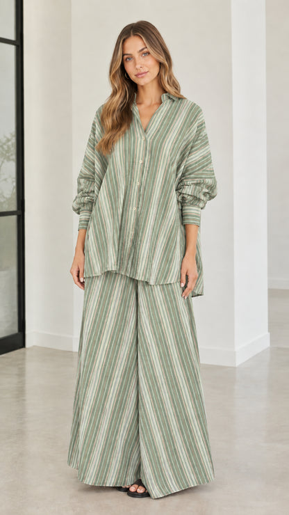 Model wearing sage green and white striped two-piece shirt and wide-leg pant set