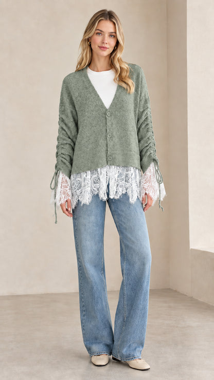 Front view of woman wearing sage green V-neck lace-trimmed knit cardigan