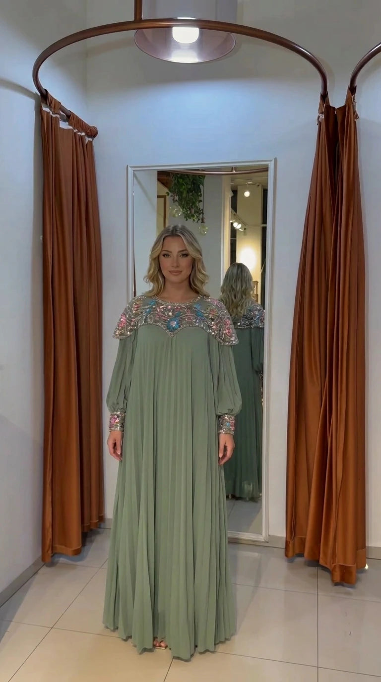 Woman wearing sage green pleated modest dress with embroidered yoke