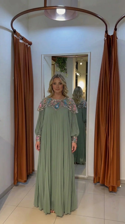 Woman wearing sage green pleated modest dress with embroidered yoke